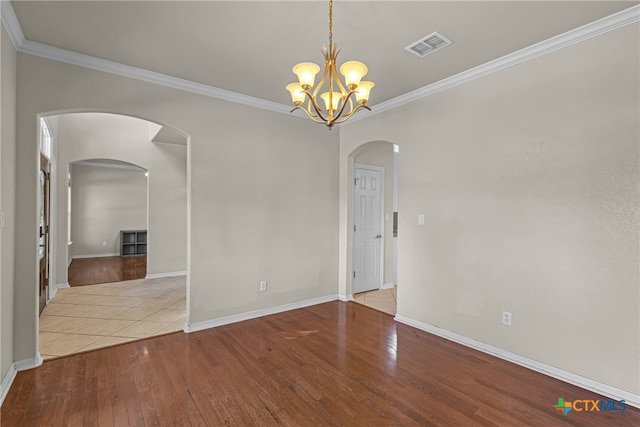 unfurnished room with a chandelier, light hardwood / wood-style flooring, and crown molding