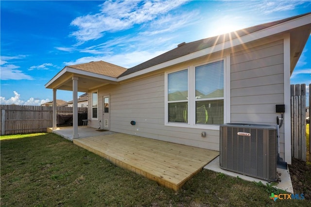 rear view of house featuring central AC, a patio, a deck, and a lawn