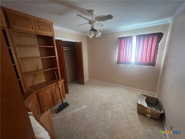 unfurnished bedroom with baseboards, ornamental molding, light carpet, a closet, and a ceiling fan