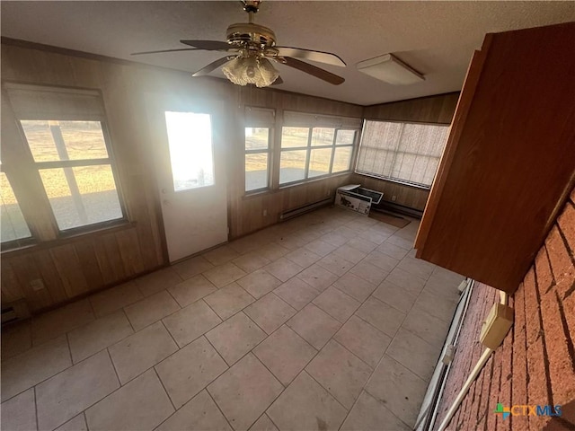 unfurnished sunroom featuring a ceiling fan