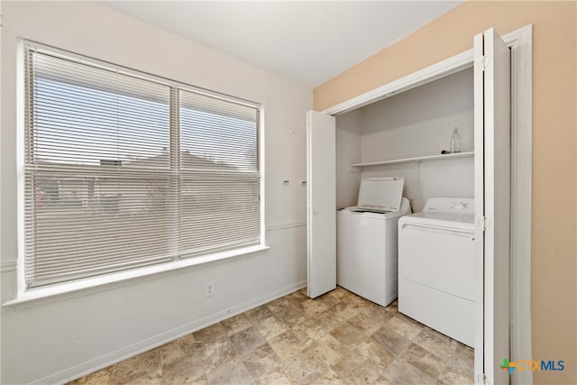 clothes washing area with independent washer and dryer and a wealth of natural light