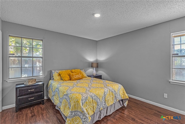 bedroom with dark wood-type flooring and a textured ceiling