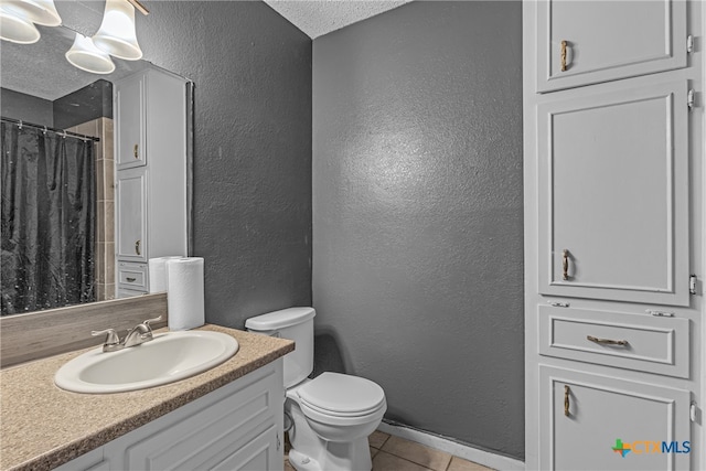 bathroom with toilet, tile patterned floors, a textured ceiling, a shower with curtain, and vanity