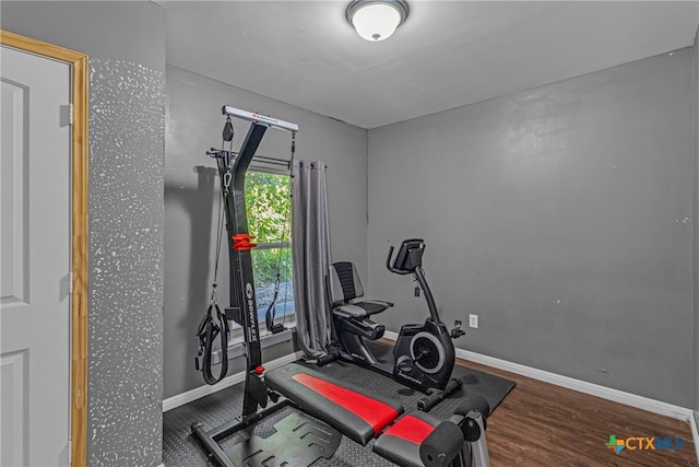 exercise room with dark wood-type flooring