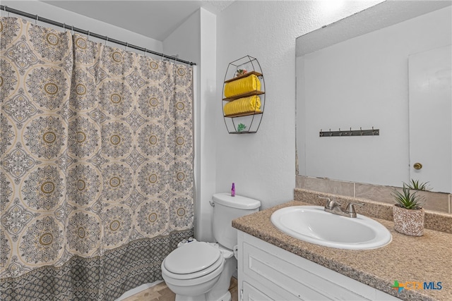 bathroom with toilet, a shower with curtain, and vanity