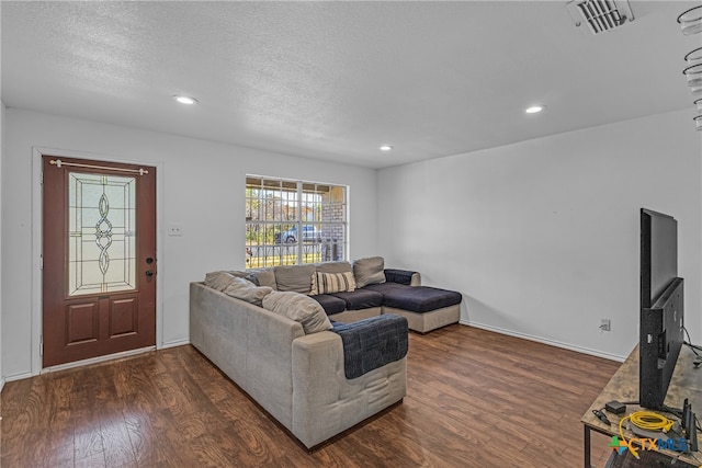 living room featuring dark hardwood / wood-style flooring and a textured ceiling