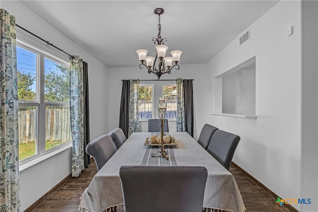 dining room with dark hardwood / wood-style flooring and a notable chandelier