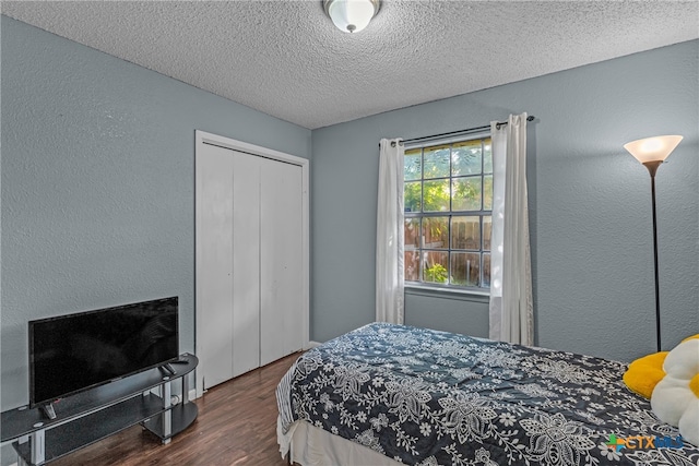 bedroom with dark wood-type flooring and a textured ceiling