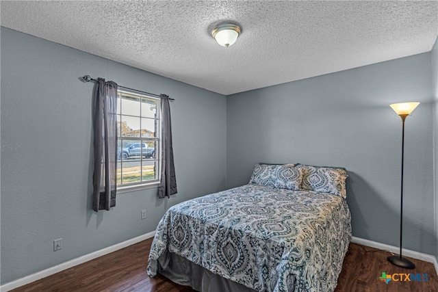 bedroom featuring dark wood-type flooring and a textured ceiling