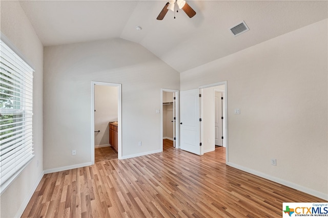 unfurnished bedroom with light hardwood / wood-style floors, ensuite bath, ceiling fan, a closet, and a spacious closet