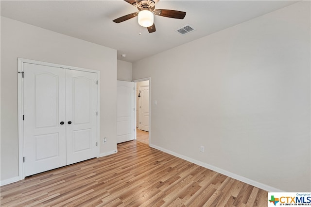 unfurnished bedroom with ceiling fan, a closet, and light wood-type flooring