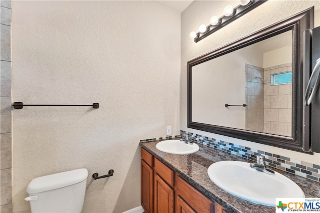 bathroom featuring toilet, backsplash, and vanity