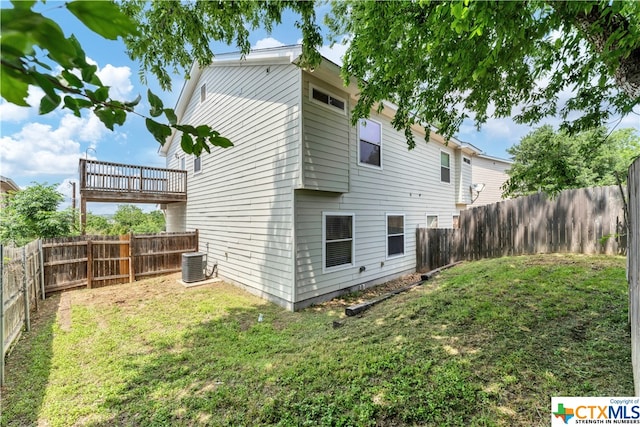 back of house featuring central AC unit and a yard