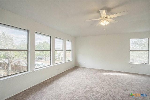 carpeted spare room with ceiling fan