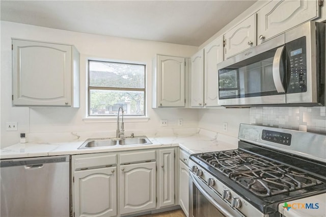 kitchen featuring white cabinets, stainless steel appliances, and sink