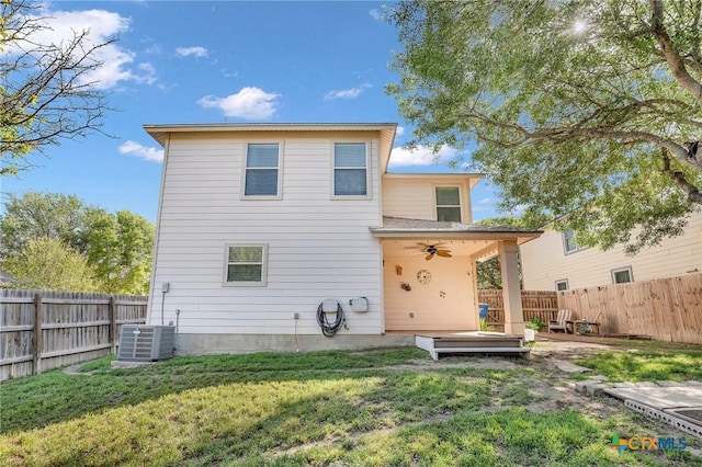 rear view of property featuring ceiling fan, a fenced backyard, a yard, and central air condition unit
