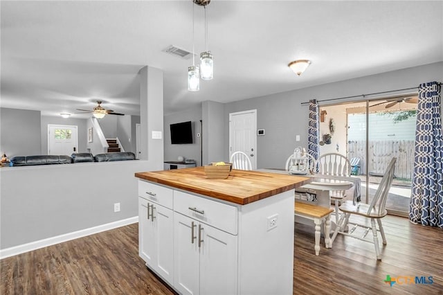 kitchen featuring white cabinets, dark wood-style floors, visible vents, pendant lighting, and wooden counters