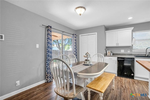 dining room featuring dark wood-style flooring, a healthy amount of sunlight, and baseboards