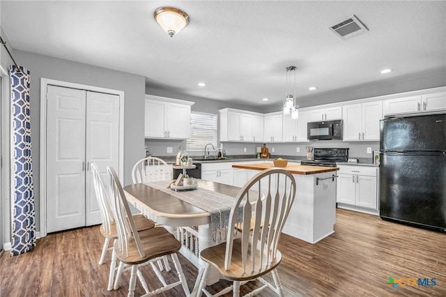dining room featuring wood finished floors, visible vents, and recessed lighting