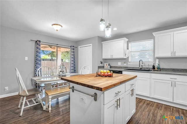 kitchen featuring dark wood-style floors, a sink, wooden counters, and a healthy amount of sunlight