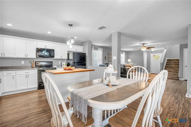 dining room with wood finished floors, visible vents, stairs, and a wealth of natural light