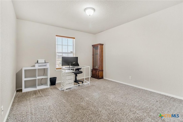 carpeted office space featuring a textured ceiling