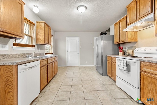 kitchen featuring a textured ceiling, sink, light tile patterned floors, and white appliances