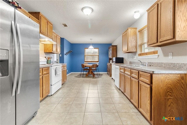 kitchen featuring pendant lighting, white appliances, sink, a textured ceiling, and light tile patterned flooring