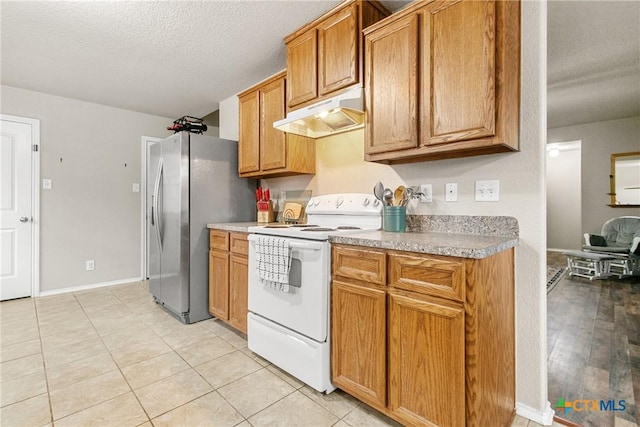 kitchen featuring white range with electric stovetop, stainless steel refrigerator, a textured ceiling, and light wood-type flooring