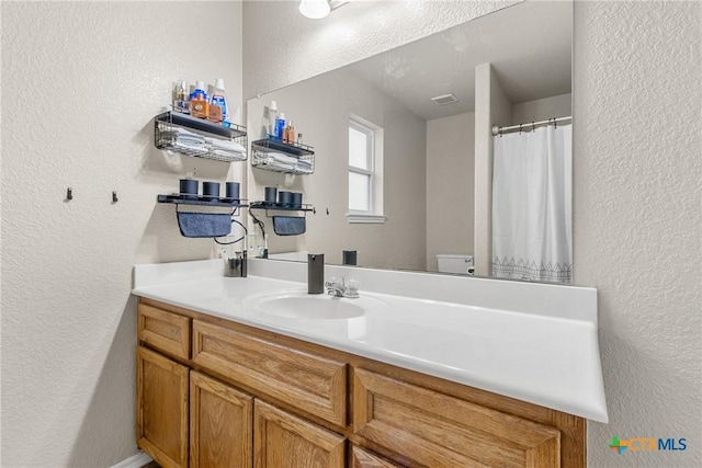 bathroom featuring vanity and toilet