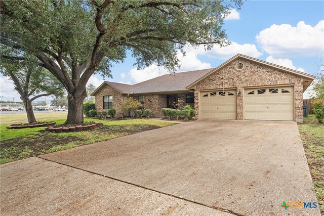 single story home featuring a garage and a front lawn