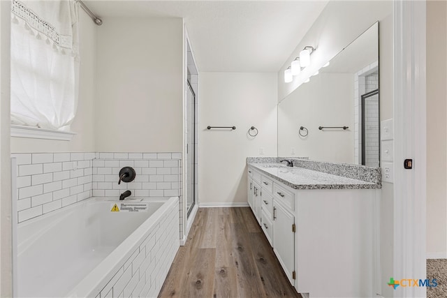 bathroom featuring hardwood / wood-style floors, shower with separate bathtub, and vanity