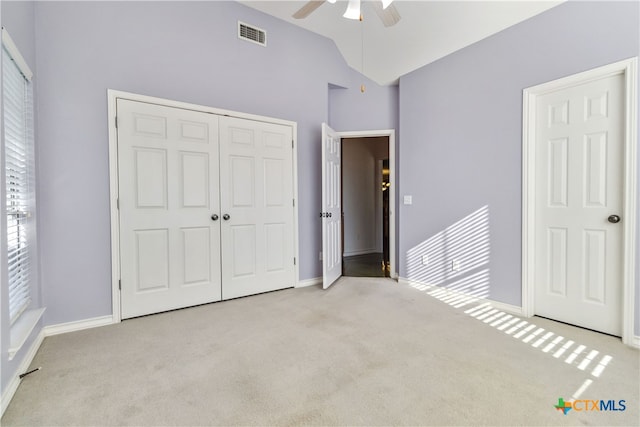 unfurnished bedroom featuring ceiling fan, multiple windows, and light colored carpet