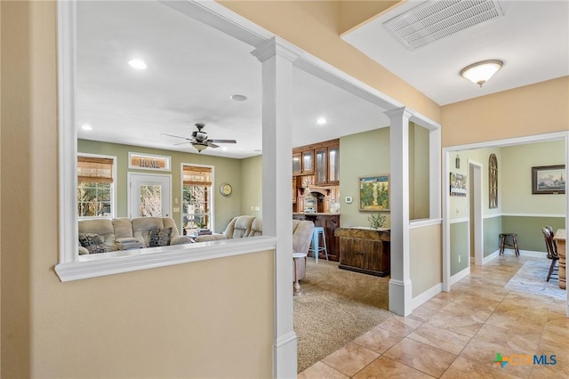 hall featuring light colored carpet and ornate columns