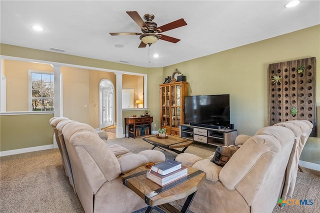 living room featuring decorative columns, light carpet, and ceiling fan