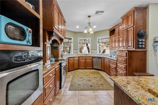 kitchen with light stone countertops, stainless steel appliances, sink, pendant lighting, and a notable chandelier