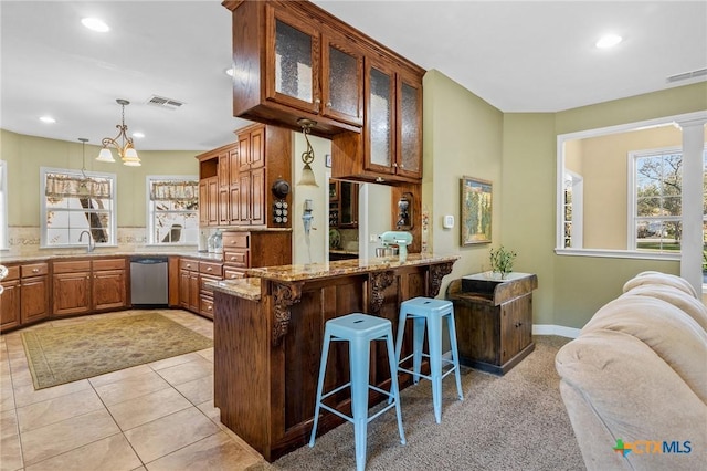 kitchen featuring dishwasher, sink, a kitchen breakfast bar, a notable chandelier, and kitchen peninsula