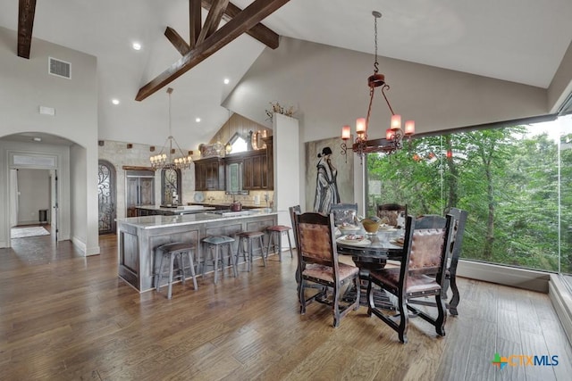 1746 Stagecoach Dr, Canyon Lake, TX 78133 - dining space with a chandelier, high vaulted ceiling, arched walkways, beam ceiling, and wood finished floors