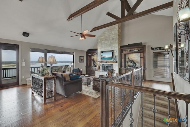 1746 Stagecoach Dr, Canyon Lake, TX 78133 - living room with ceiling fan, wood finished floors, high vaulted ceiling, beam ceiling, and a stone fireplace