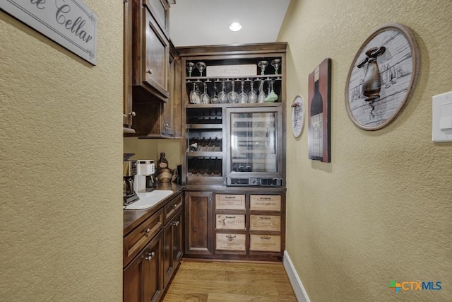 1746 Stagecoach Dr, Canyon Lake, TX 78133 - bar featuring a textured wall, light wood finished floors, and wine cooler