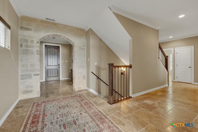 1746 Stagecoach Dr, Canyon Lake, TX 78133 - hall with stone tile flooring, arched walkways, recessed lighting, ornamental molding, and an upstairs landing