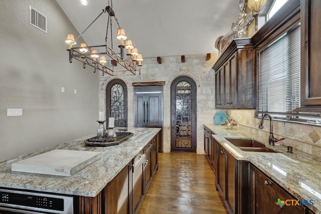 1746 Stagecoach Dr, Canyon Lake, TX 78133 - kitchen with arched walkways, a center island, wood finished floors, light stone countertops, and lofted ceiling