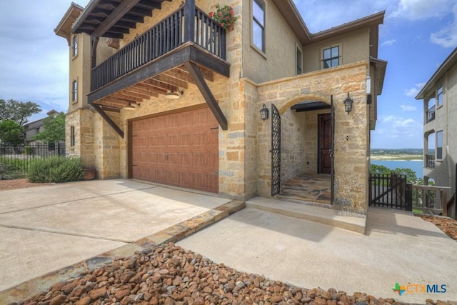 1746 Stagecoach Dr, Canyon Lake, TX 78133 - view of front facade featuring a balcony, stone siding, an attached garage, and a water view