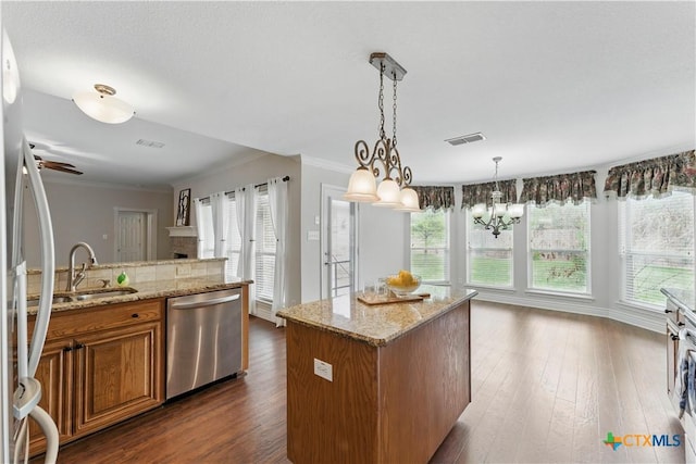 1711 Kelly Ct, New Braunfels, TX 78130 - kitchen with dishwasher, brown cabinets, healthy amount of natural light, crown molding, and dark wood-style flooring