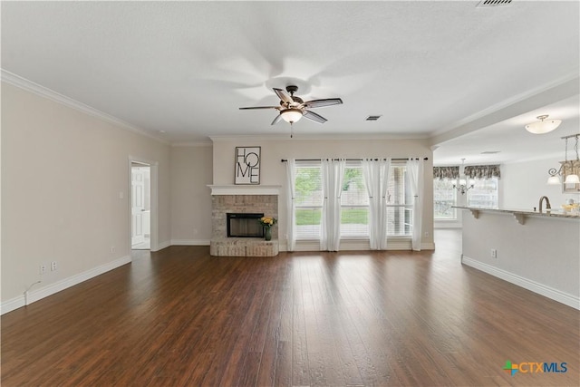 1711 Kelly Ct, New Braunfels, TX 78130 - unfurnished living room with a ceiling fan, a fireplace, dark wood finished floors, ornamental molding, and a chandelier