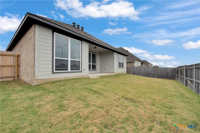 rear view of house featuring a yard and a patio area