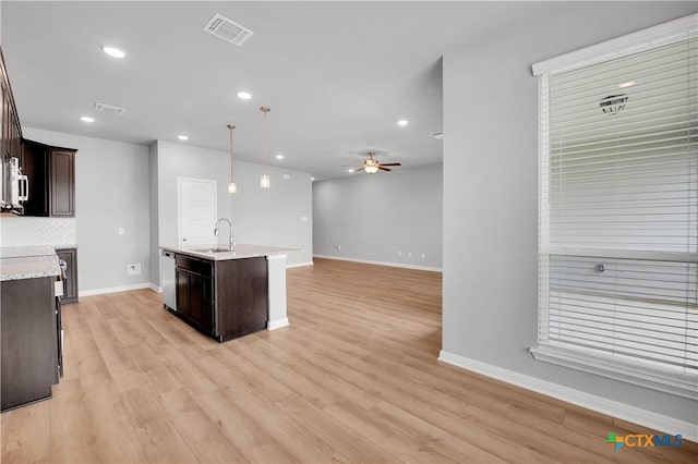 kitchen with pendant lighting, sink, ceiling fan, dark brown cabinets, and stainless steel dishwasher