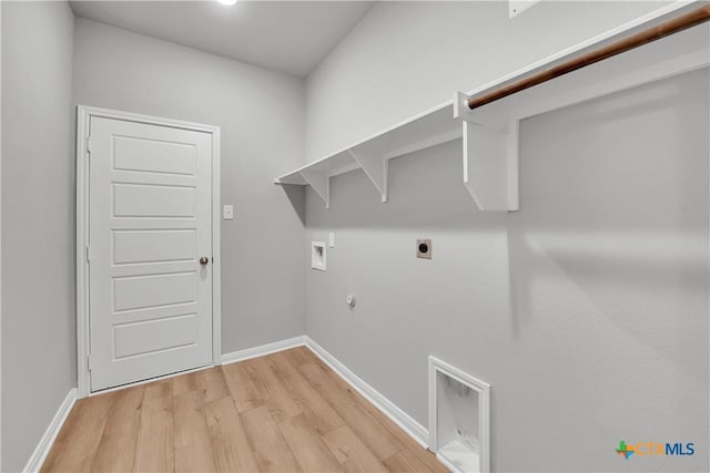 clothes washing area featuring electric dryer hookup, washer hookup, light hardwood / wood-style flooring, and gas dryer hookup