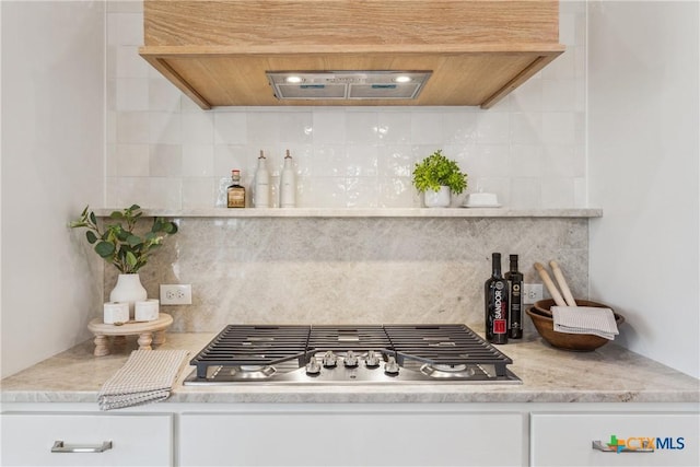 1702 Kellan Dr, Salado, TX 76571 - kitchen with stainless steel gas cooktop, premium range hood, decorative backsplash, and white cabinets