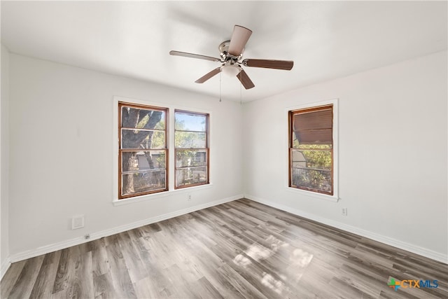 spare room with hardwood / wood-style floors and ceiling fan